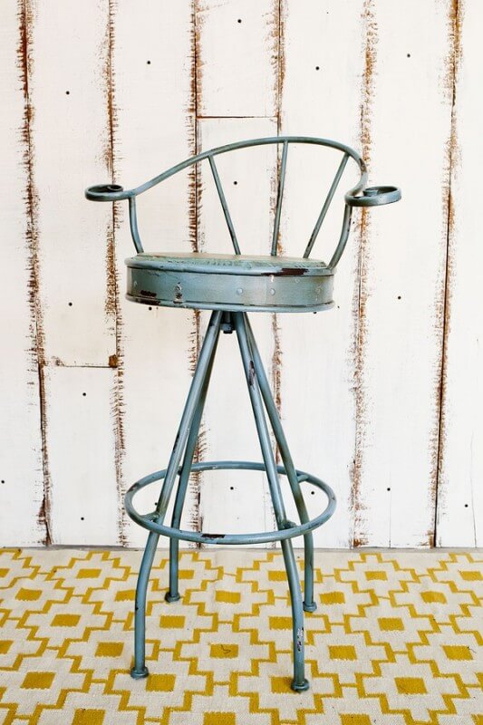 Vintage Stool With White Wooden Background.