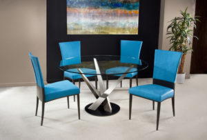 Round glass top dining table and blue upholstered chair.