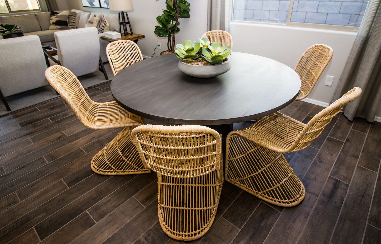 Round Wooden Table With Centerpiece And Wicker Chairs