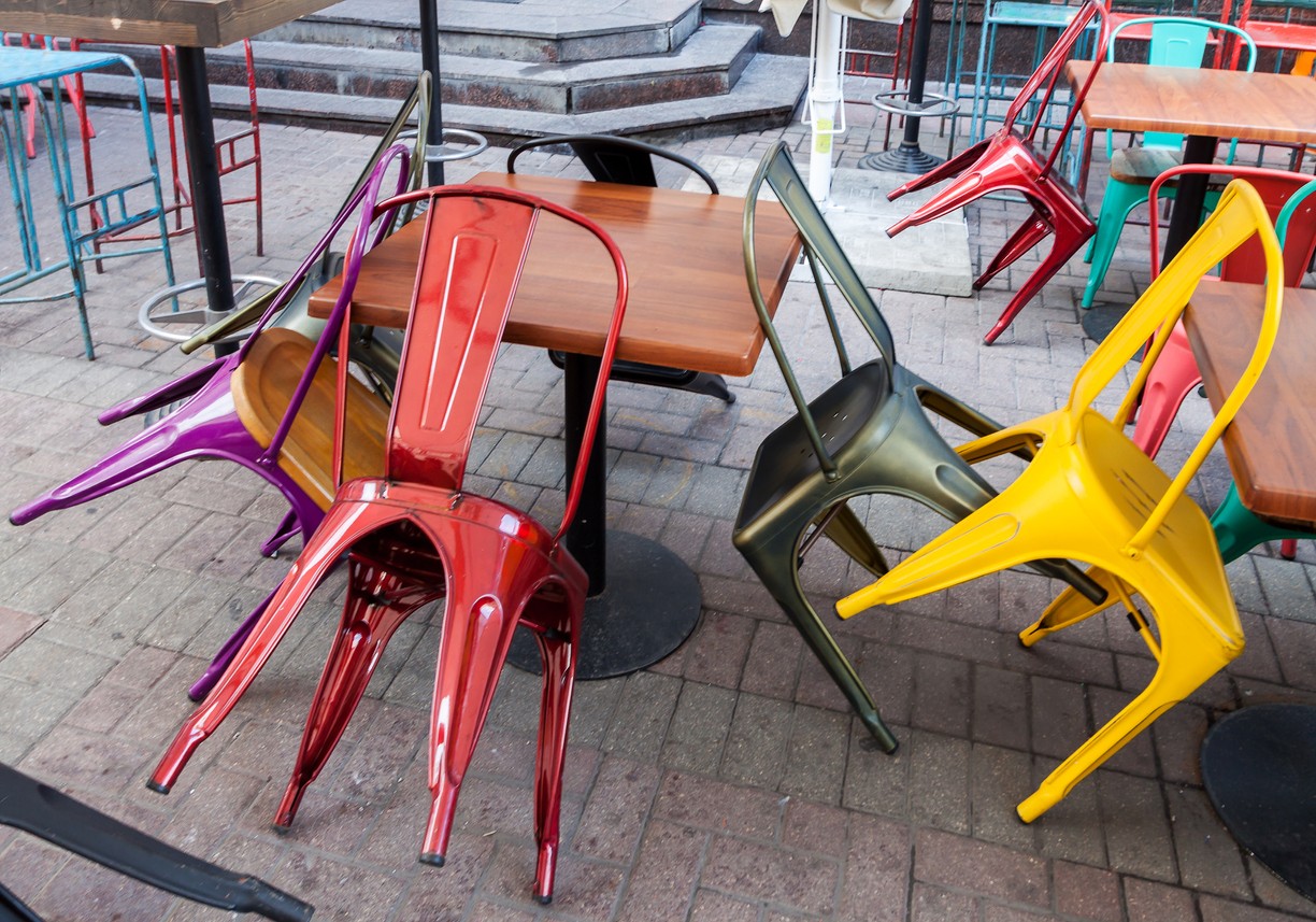 Colorful metal restaurant chairs on an outdoor patio. 