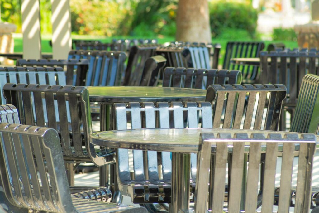 Steel restaurant tables and chairs on an outdoor patio.