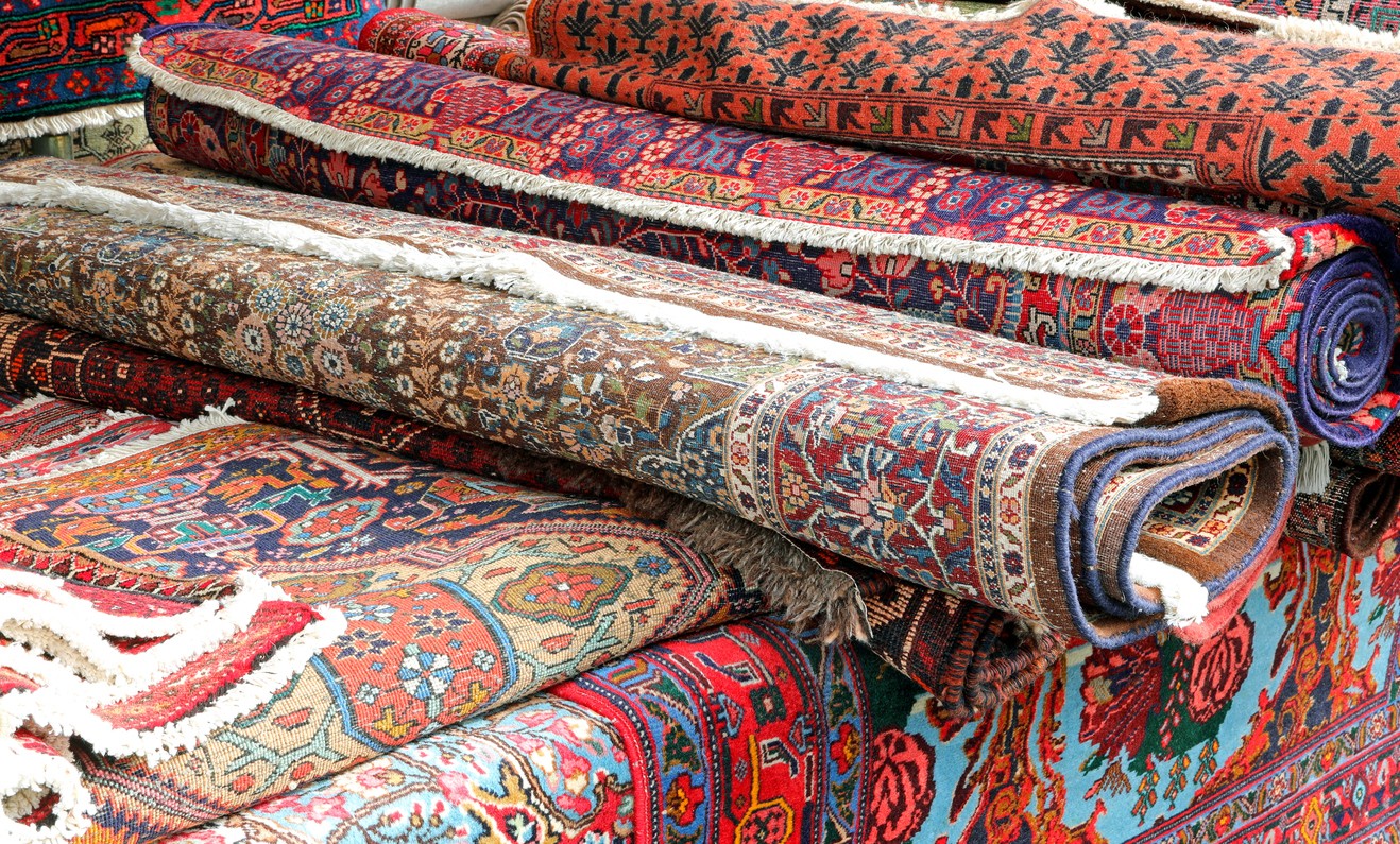 Colorful Persian style rugs piled on top of one another. 