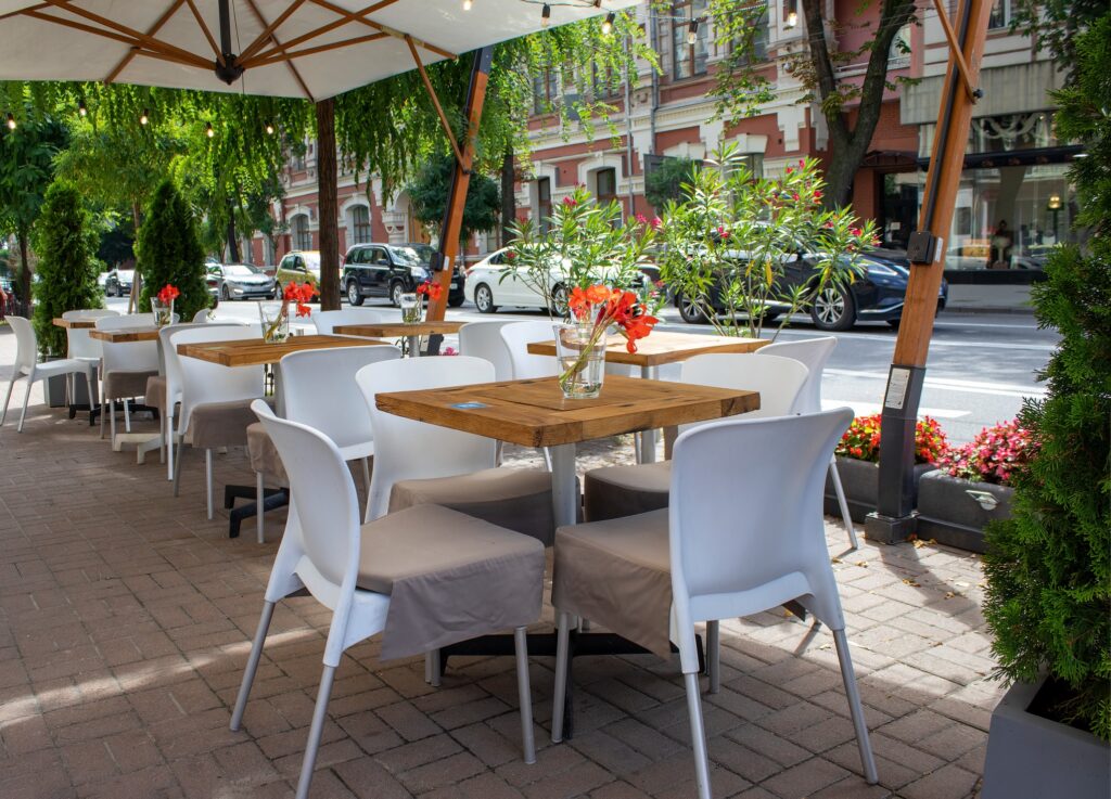 An outdoor restaurant patio with tables and umbrellas. 
