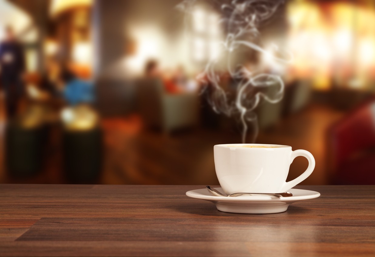 Steam cup of coffee at bistro table dining set.