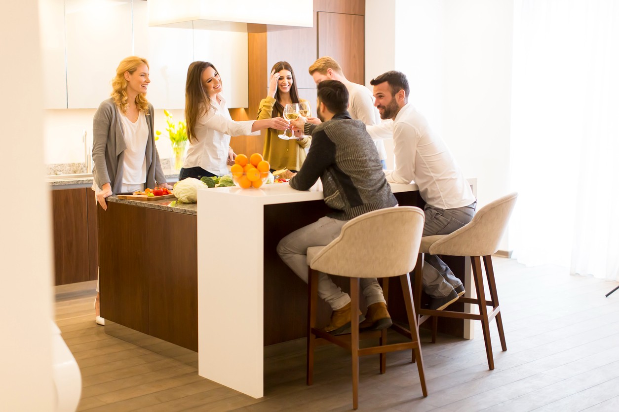 Friends eating around a kitchen island with modern barstools.